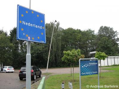 Noord Deurningen, grensovergang, borden aan de Nederlandse zijde van de Rammelbeek die de grens tussen Nederland en Duitsland markeren. Het hectometerpaaltje 24,922 staat aan de Nederlandse zijde van de beek en geeft de afstand tot Lingen (Ems) aan.