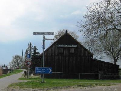 Schaphalsterzijl, buurtschapsgezicht, met plaatsnaambord en houten loods van waterschap Noorderzijlvest