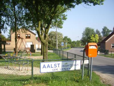 Toen buurtschap Aalst bij Lienden een bebouwde kom kreeg, en daarmee blauwe plaatsnaamborden, is een van de oude, witte plaatsnaamborden als aandenken opgehangen bij de speeltuin in de buurtschap. (© H.W. Fluks)