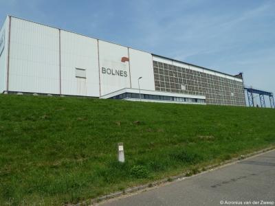 Het omvangrijke complex van scheepswerf NMC ligt deels in Bolnes, gemeente Ridderkerk, maar dit gebouw van hen, dat weliswaar Bolnes heet, staat op Oostdijk 25 en valt daarmee nét onder de aangrenzende wijk Beverwaard in de gemeente Rotterdam.