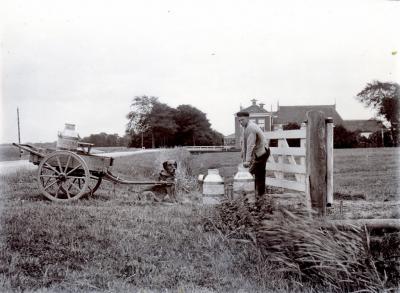 Foto uit ca. 1900 van een boer die net klaar is met melken en zijn melkbussen op de hondenkar aan het zetten is. Op de achtergrond Herberg De Groote Bontekoe. Voor nadere toelichting op de foto, zie het kopje Beeld en www.zoekplaatjes.nl/2200/2250.html.