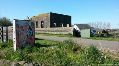 Nieuwe Schans, ruïne van het gemaal van de Rijkse Sluis, met links op de voorgrond een kleurig kunstwerk als onderdeel van een kunstroute
