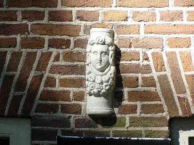 Een van de weinige overblijfselen van de borg Rheebruggen: een keramisch ornament, vermoedelijk afkomstig van een schouw uit de 17e eeuw en ingemetseld in de voorgevel van een boerderij op het gelijknamige landgoed. (© https://groninganus.wordpress.com)