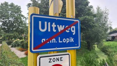 Bij een van de locaties waar je de buurtschap Uitweg verlaat, wordt de plaatsnaam op het einde-kom-bord gespeld als Ultweg, oftewel daar is de bordenmaker letterlijk het 'puntje op de i' vergeten. (© Robin Smolders / www.robinfietst.nl)