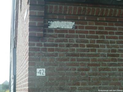 Het straatnaambordje Zandspui aan de gevel van huisnr. 42 is niet heel goed meer te lezen. Gelukkig staat een paar meter verderop aan de T-splitsing een straatnaambordje dat wél goed te lezen is.
