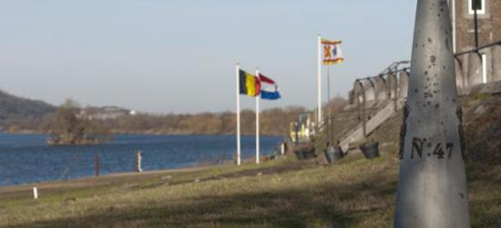 Eijsden, grenspaal en landenvlaggen aan de Maas