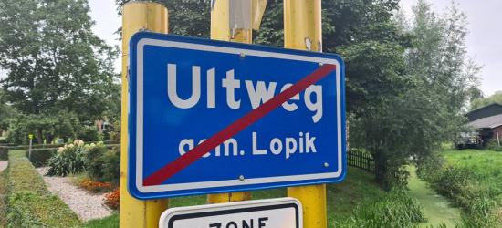 Bij een van de locaties waar je de buurtschap Uitweg verlaat, wordt de plaatsnaam op het einde-kom-bord gespeld als Ultweg, oftewel daar is de bordenmaker letterlijk het 'puntje op de i' vergeten. (© Robin Smolders / www.robinfietst.nl)